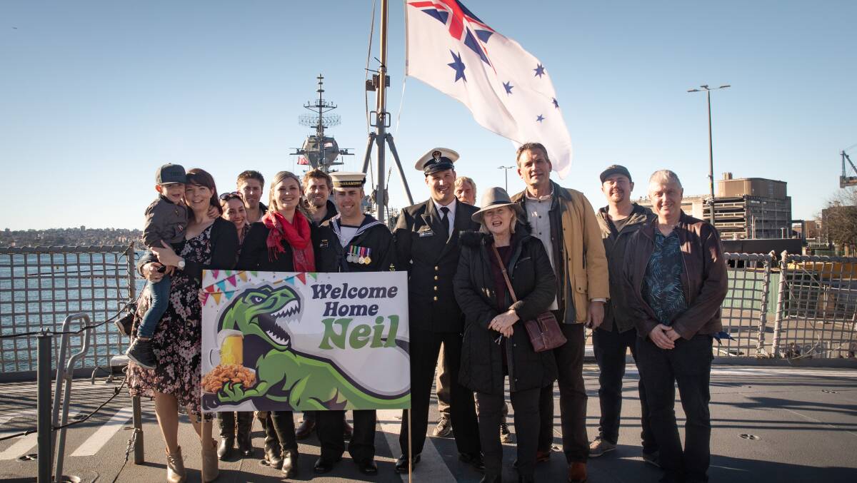 WELCOME HOME: Petty Officer Mark Hibbins and Leading Seaman Neil Gough with their families at the return of HMAS Warramunga. Picture: LSIS Kayla Jackson