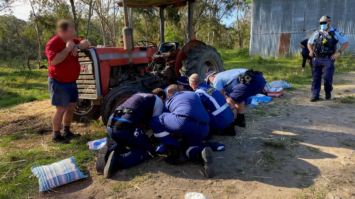 The CareFlight medical team attend to an elderly man who sustained injuries after falling off his tractor at Cattai on Sunday, October 24. Picture: CareFlight