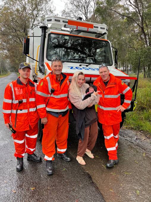 HELPING HANDS: NSW SES Hawkesbury Unit volunteers move a Gronos Point mum and her six-week-old baby, Havana, over 400 millimetres of water to her waiting friends. Picture: NSW SES Hawkesbury Unit/Facebook