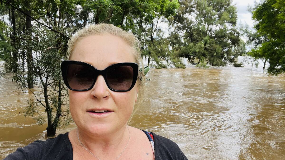 Windsor resident Emma-Jane Garrow with flood waters filling her backyard at Windsor Peninsula. Picture: Supplied