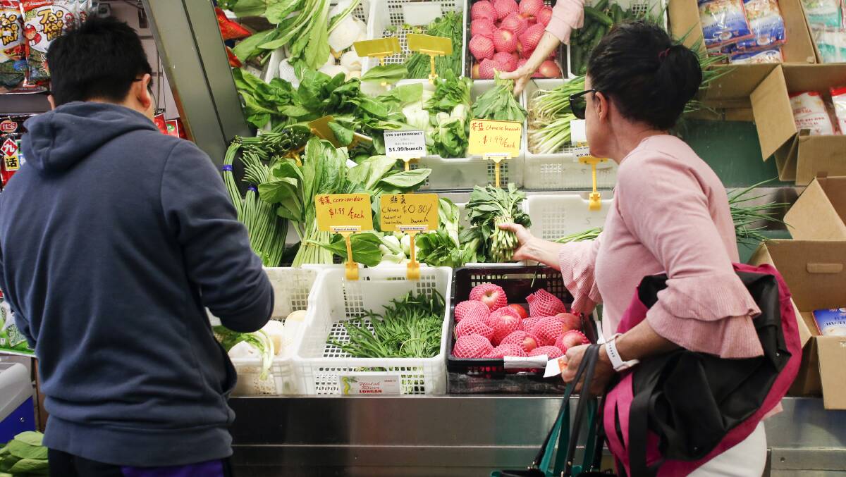 Shoppers picking out fresh produce. Photo: Anna Warr