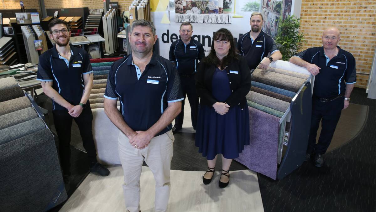 Proud to serve: Brendon James with his staff at McGraths Hill Carpet Court. The showroom is open seven days a week. Picture: Geoff Jones