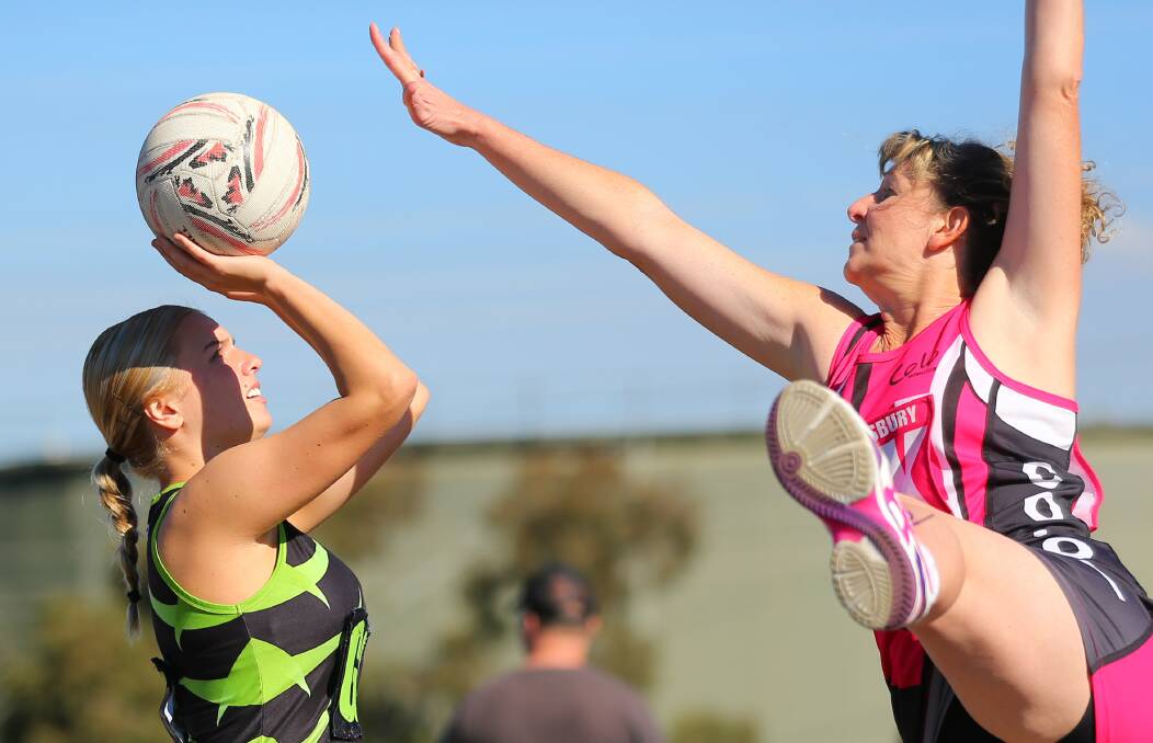Macquarie's Jessica Bunting goes for a shot on goal as her Colo opponent tries to block the shot. Picture: Geoff Jones