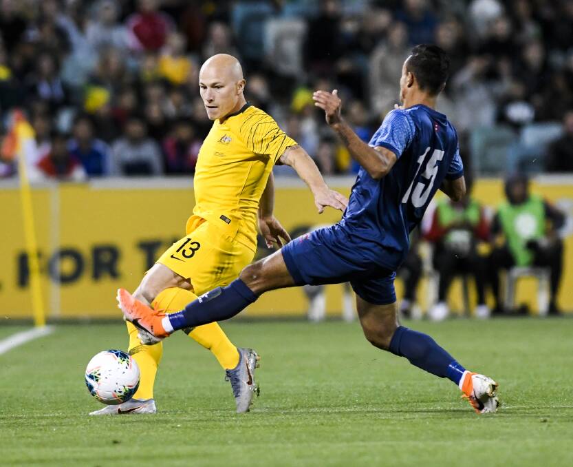 Sujal Shreshtha attempts to intercept Aaron Mooy (above) while (below) more than 18,000 fans packed Canberra Stadium. Pictures: Dion Georgopoulos