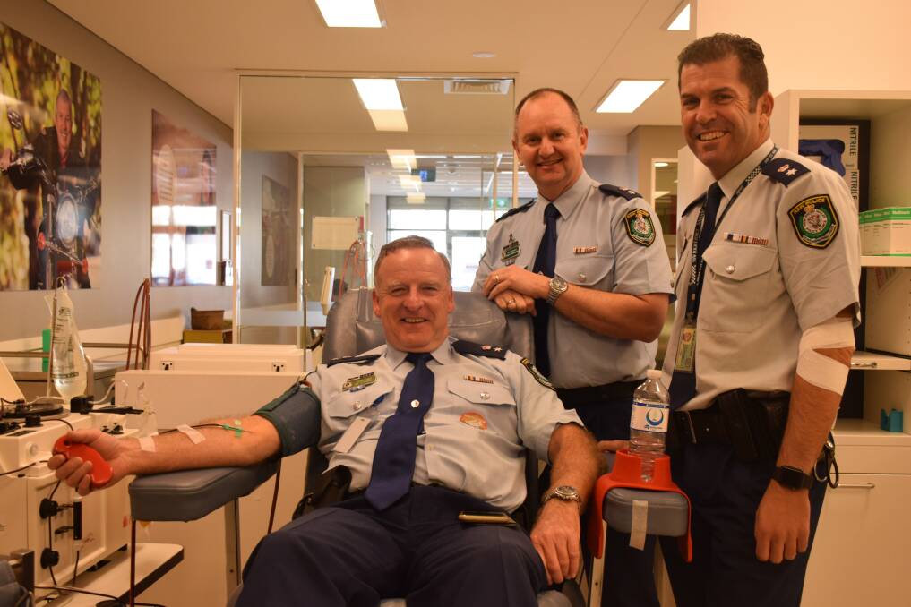 Rolling up sleeves: Hawkesbury Police Area Commander Detective Superintendent Jim Stewart gives blood as part of the challenge, watched by Nepean Commander Det Supt Brett McFadden and former Hawkesbury commander now head of the Dog Unit, Superintendent Steve Egginton.