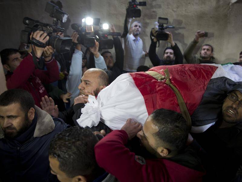 Mourners carry the body of activist Amal al-Taramsi, 43, after she was killed by Israeli troops.