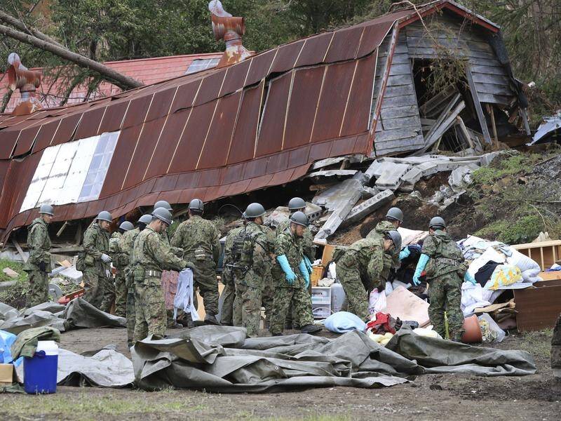 Japanese defence personnel search the wreckage from a powerful quake that killed 44 people.