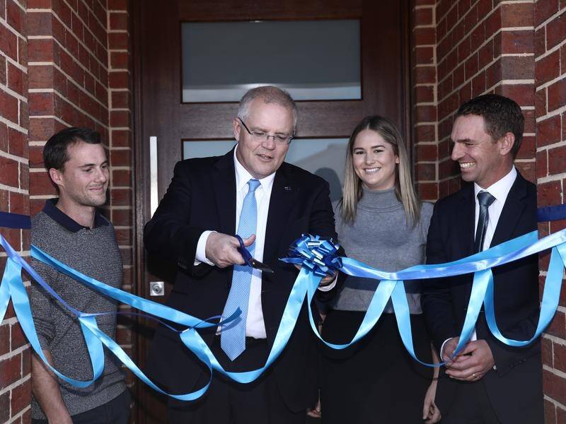 Scott Morrison cuts the ribbon for first home owners Andy and Caitlin at their new home.