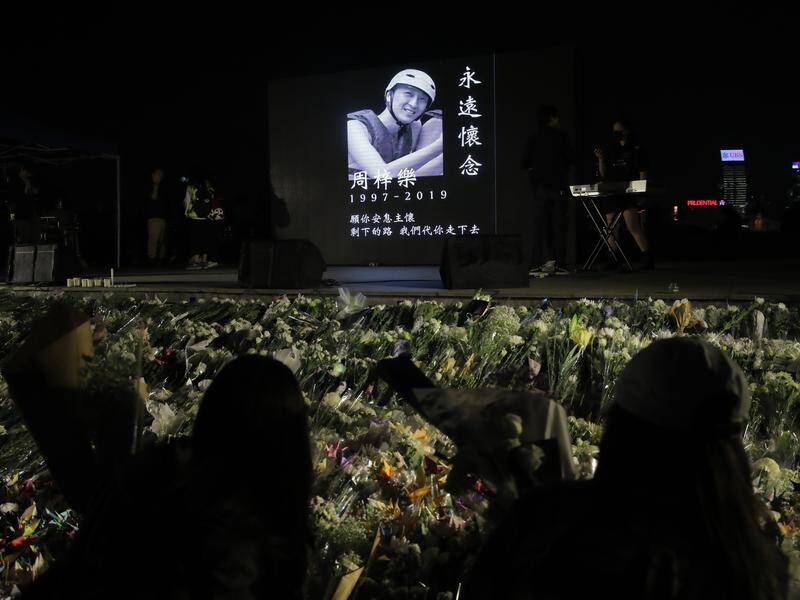 A vigil has been held for a student killed amid protests in Hong Kong as lawmakers were arrested.