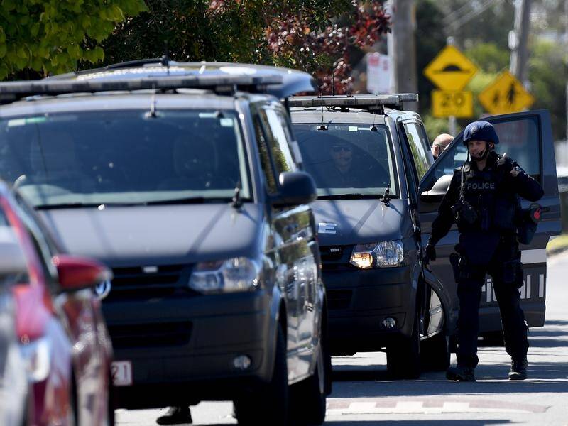 Two police officers were injured when they raided a Melbourne home, looking for Nghi Le.