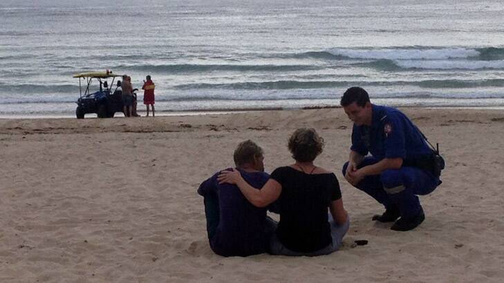 Bystanders comfort each other at Tathra Beach. Photo: Bega District News