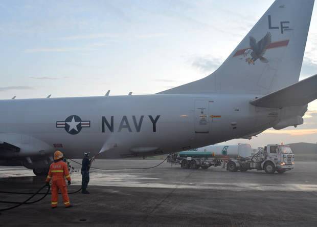 A US Navy airman sprays down a P-8A Poseidon with fresh water before its flight to assist in search and rescue operations for Malaysia Airlines flight MH370. Photo: USNavy
