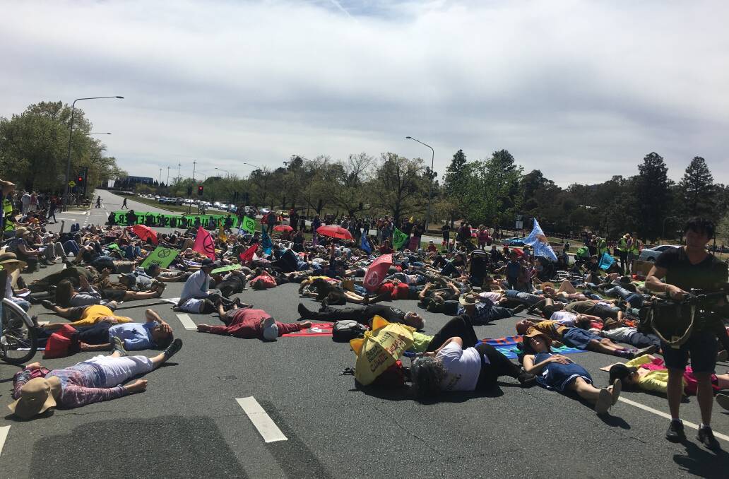 Climate action protesters stage a "die-in" while blocking traffic on Canberra's Commonwealth Avenue on Monday. Picture: Peter Brewer
