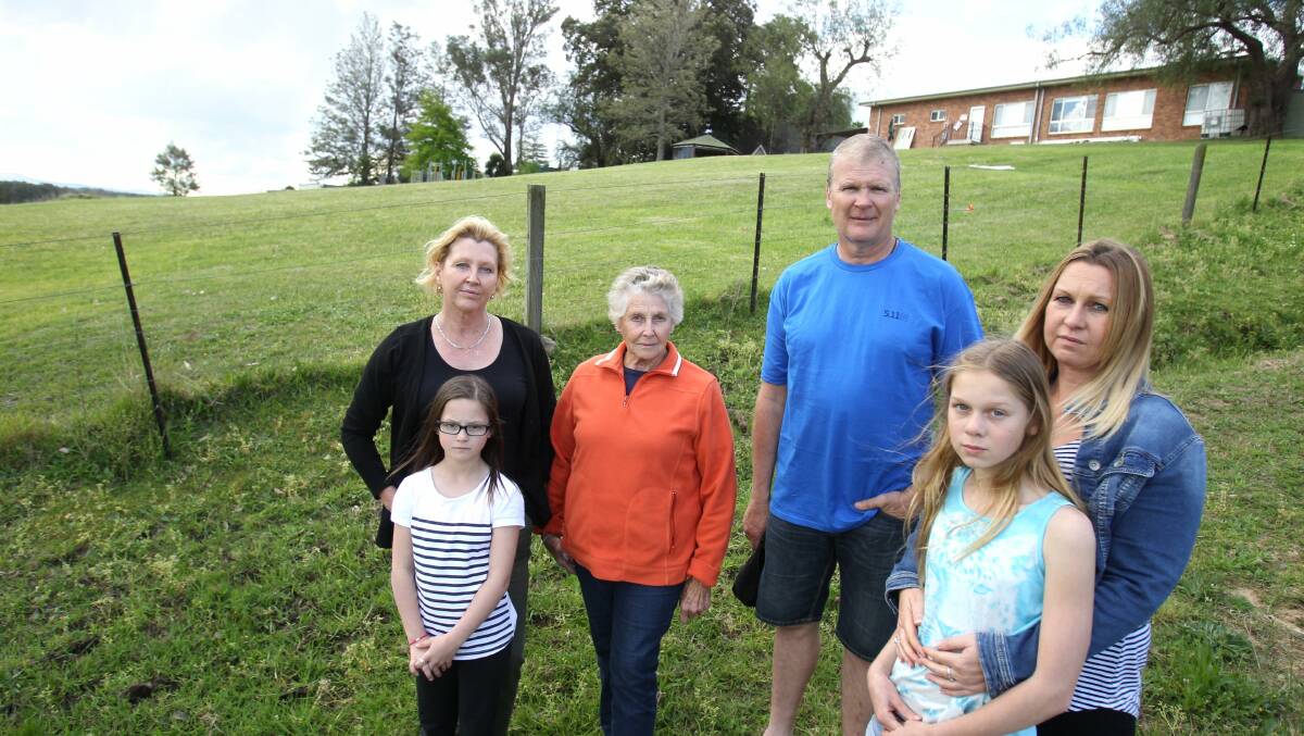 Opposed: Sandra Connor, her mother Pat Turner, their young neighbour, Makayla Atkins, and neighbours Greg Carroll and Kellie Cooper-Durant, with Kellie’s daughter, Sophie, near the proposed development site on St James’ Church’s land. Sandra and Brett Connor spoke against the DA proposal at the December 8 Council meeting. Picture: Gene Ramirez
