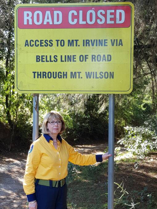 Mount Wilson-Mount Irvine Rural Fire Brigade executive member Elizabeth Montano stands in front of the closed track, which the brigade wants upgraded to fire trail status. Picture: Supplied