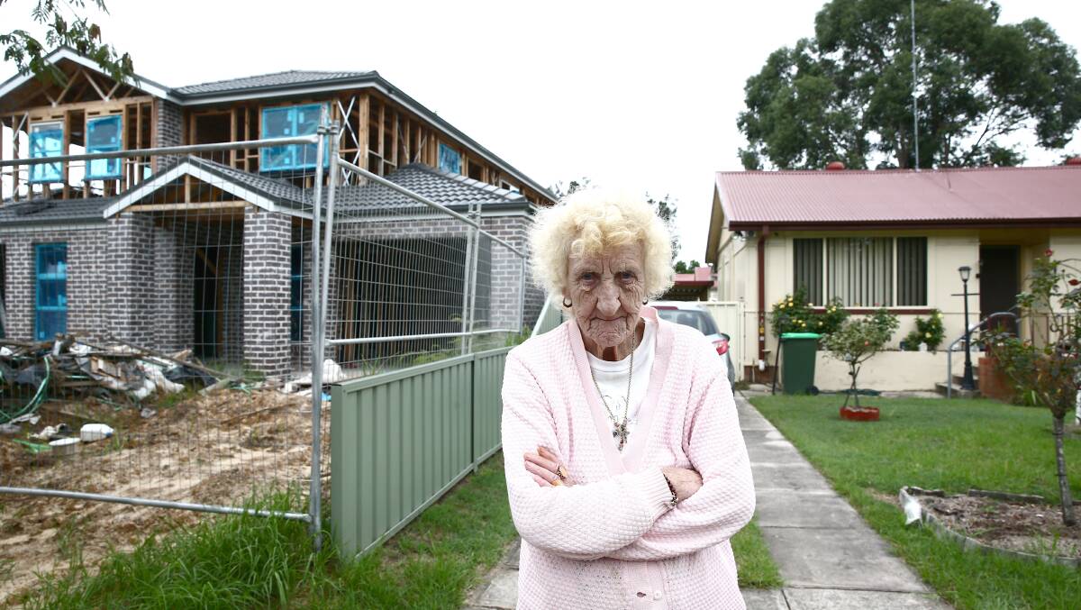 Theresa McArthur in front of her home, with the duplex construction visible next door. Picture: Geoff Jones