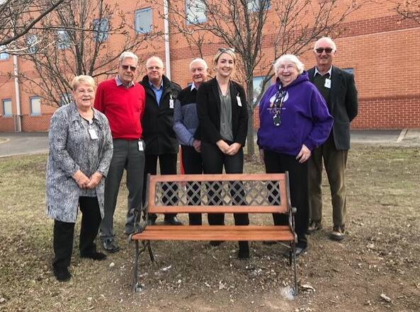 Community Board of Advice members with one of the seats installed to give people a break from the long walk to the hospital's back car park. Picture: Supplied