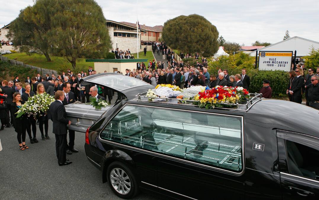 The coffin is placed in the hearse after the funeral service for John McCar...